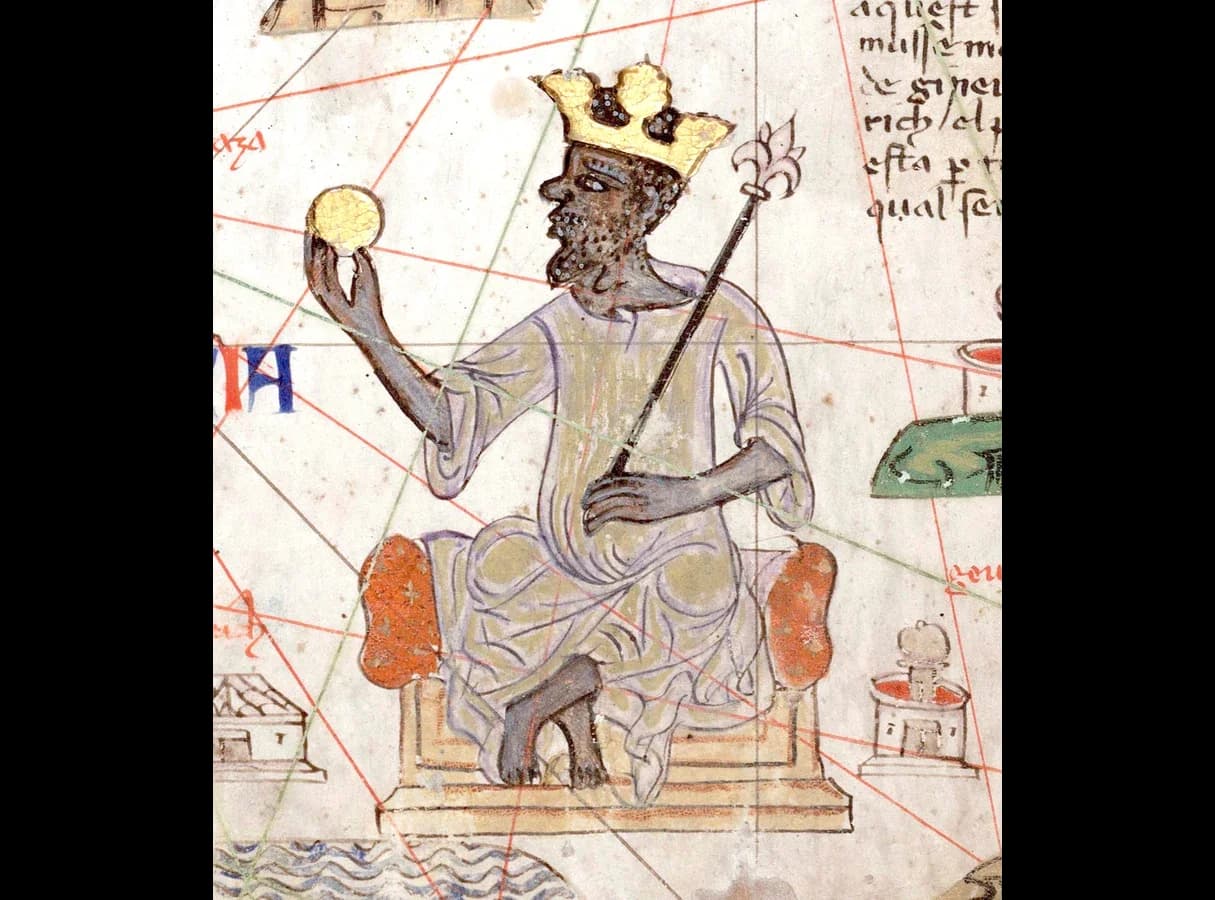 Detail of a medieval map: a crowned, bearded African king in a long robe sits on a throne, holding up a large gold nugget or coin in one hand and a sceptre in the other, with map lines and Catalan writing around him.