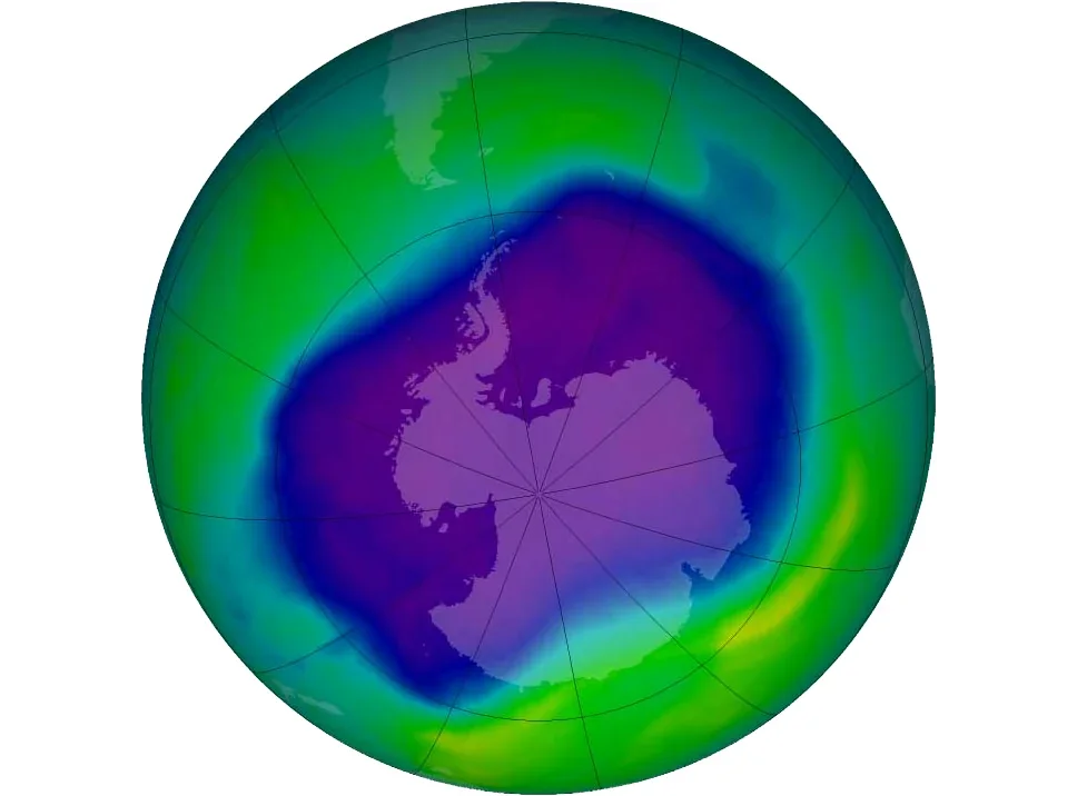 Satellite map of total ozone over the southern hemisphere on 24 September 2006. A large purple and blue region of very low ozone covers all of Antarctica and the seas around it, surrounded by green and yellow regions of normal ozone.