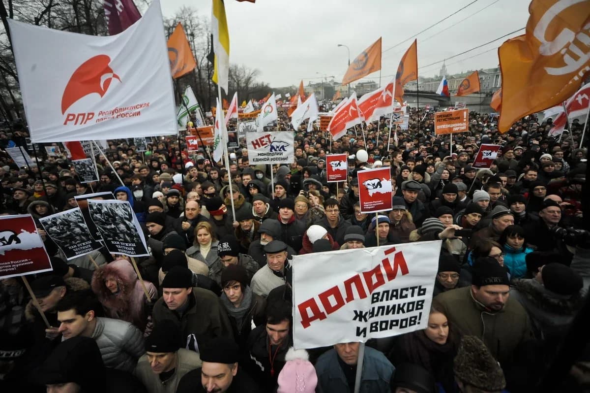 Photograph of a large crowd of demonstrators filling Bolotnaya Square in Moscow on a winter day, with flags and banners.