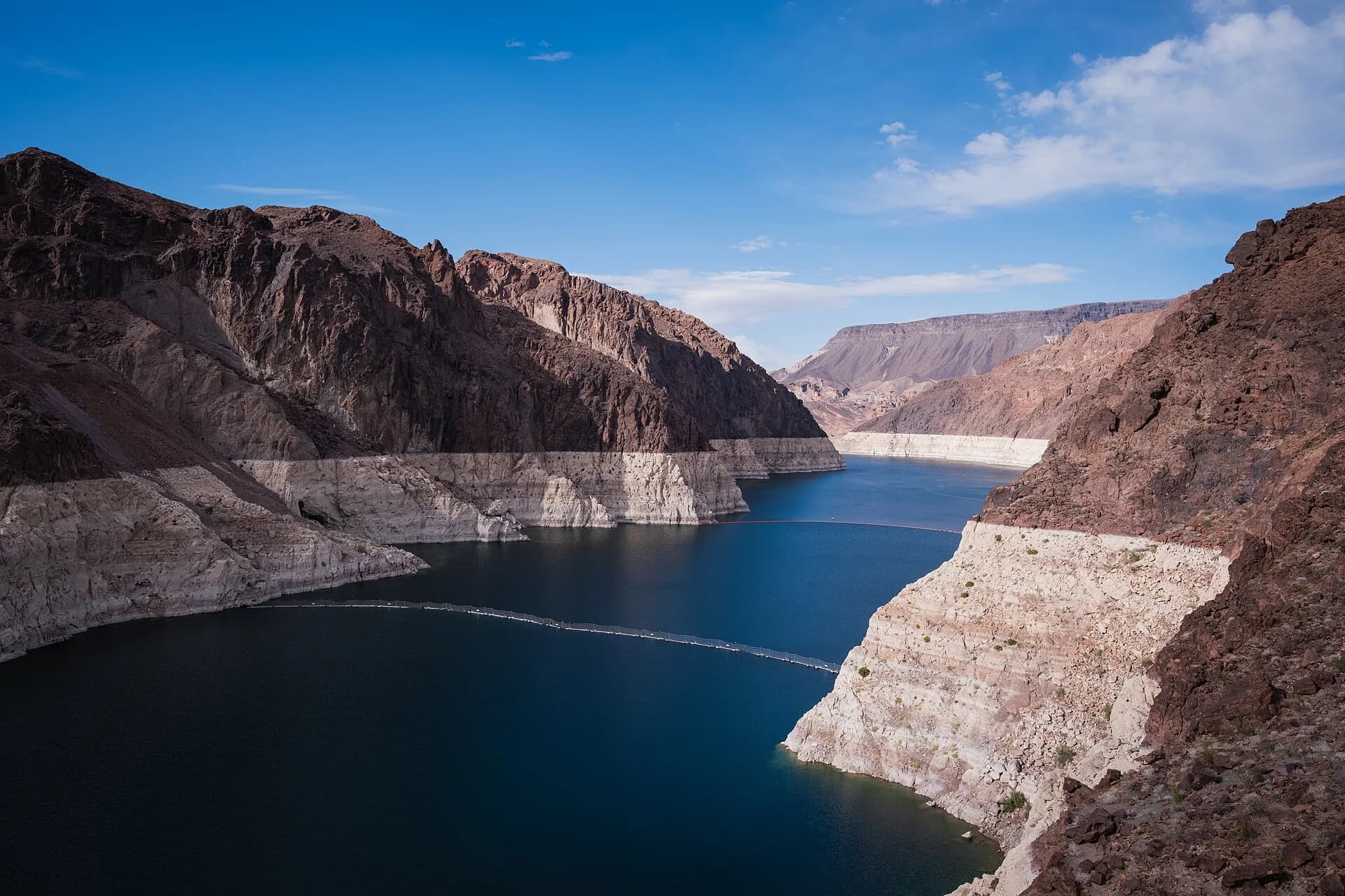 Lake Mead, a reservoir in a desert canyon above Hoover Dam in the United States, with a tall band of pale rock along its shores showing how far the water level has fallen below its former height.