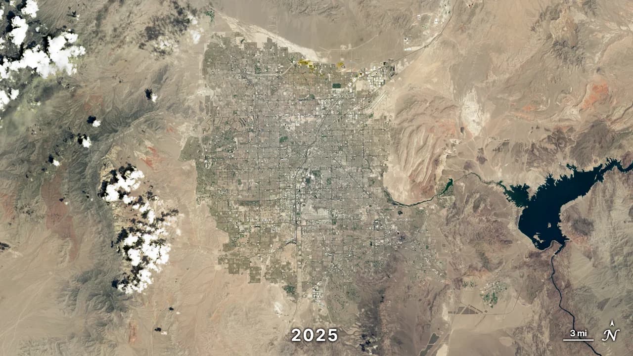 Landsat satellite image of Las Vegas in 2025: a grid of low-density suburbs covering the desert basin floor, surrounded by bare mountains, with Lake Mead to the east.