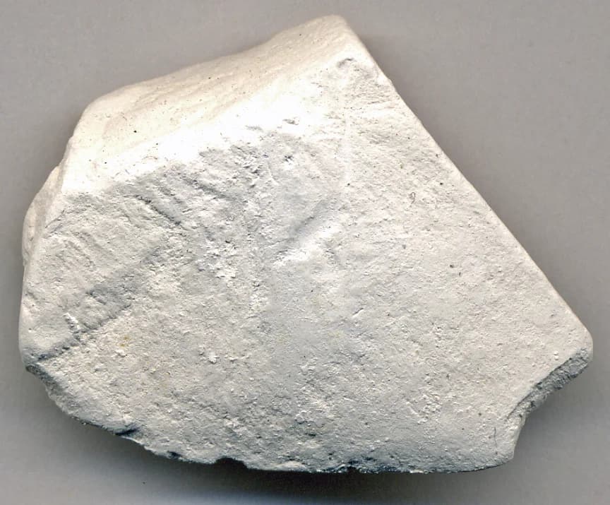 A hand sample of white, fine-grained chalk from the Upper Chalk Formation of the White Cliffs of Dover, a soft limestone made of calcium carbonate.