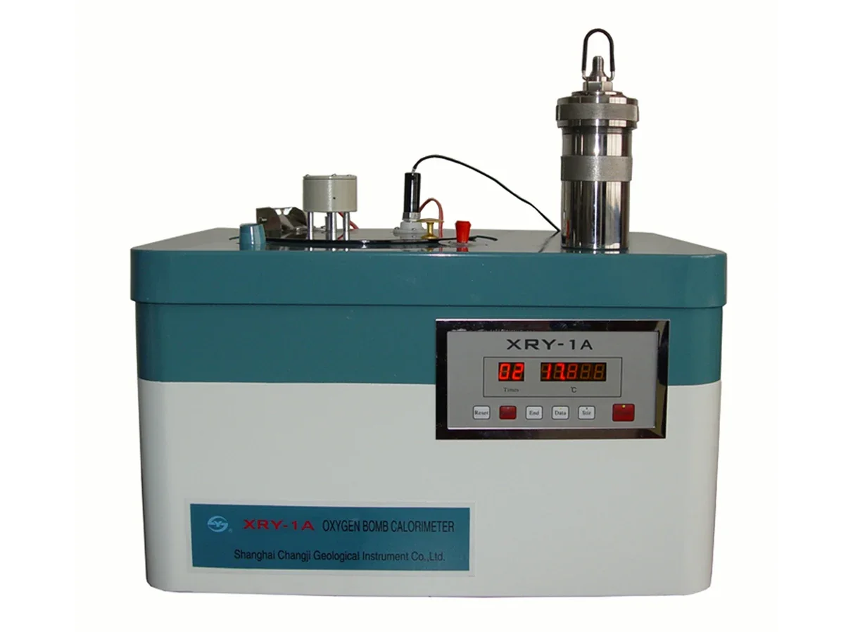 A laboratory oxygen bomb calorimeter: a large box-shaped instrument with a digital temperature display on the front and a cylindrical stainless steel bomb standing on top.