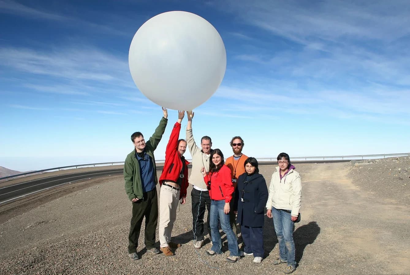 A group of researchers holds up a gas-filled weather balloon, about 1.5 m across, before its launch at ESO’s Paranal Observatory in Chile.